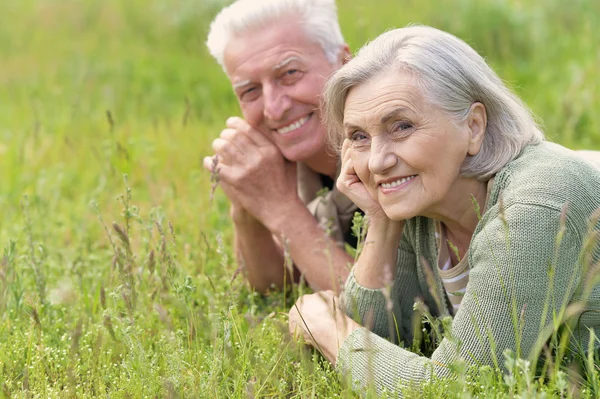 Ouder paar liggen op gras — Stockfoto