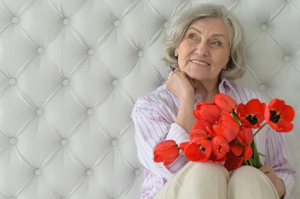 Senior woman with blooming poppies — Stock Photo, Image
