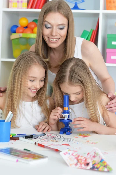 Mãe com suas filhas fazendo lição de casa — Fotografia de Stock