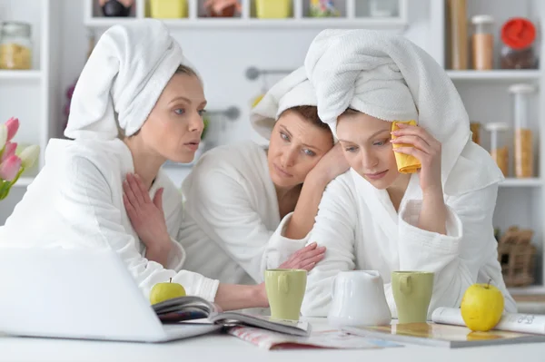 Mujeres con albornoces blancos con portátil — Foto de Stock