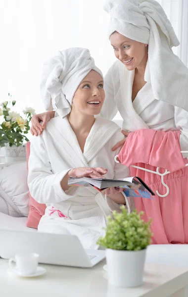 Mujeres con albornoces blancos con portátil — Foto de Stock