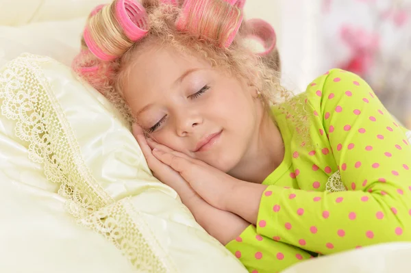 Chica en rulos de pelo durmiendo en su cama — Foto de Stock