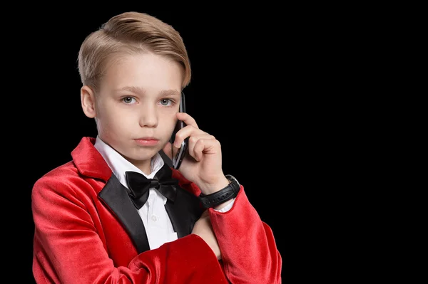 Маленький мальчик в смокинге с мобильным телефоном — стоковое фото