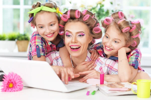 Mädchen und Mutter in Lockenwicklern mit Laptop — Stockfoto