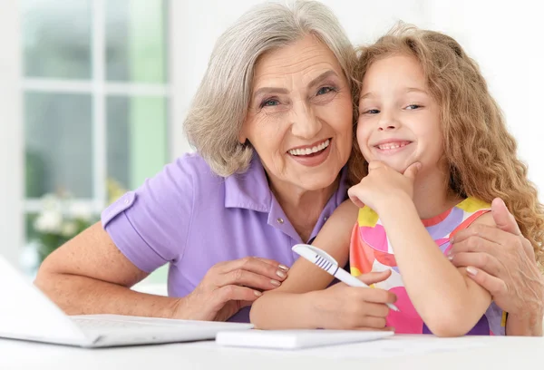 Dizüstü bilgisayar kullanarak büyükanne ile küçük kız — Stok fotoğraf