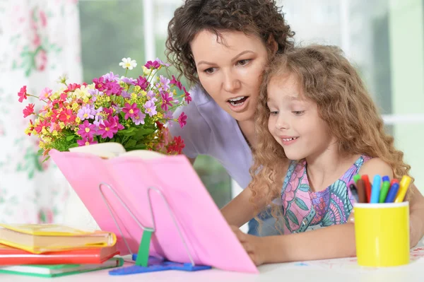 Mamma att hjälpa dottern med läxor — Stockfoto