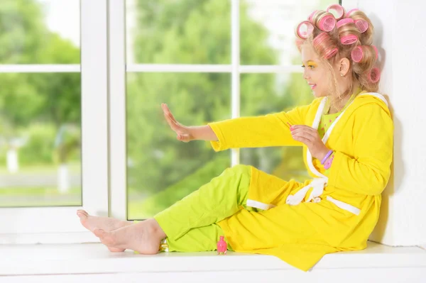 girl in hair curlers and nail polish