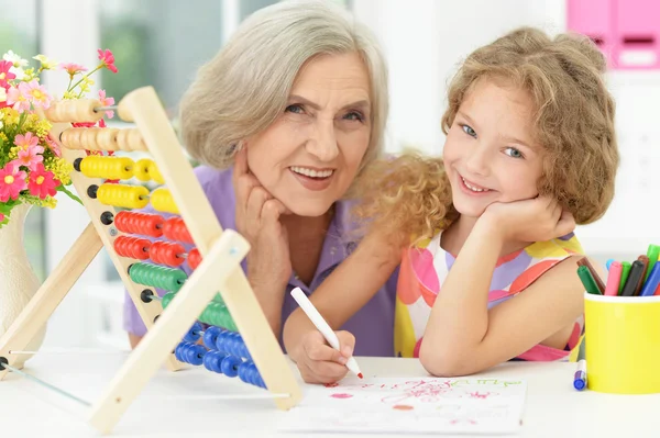 Meisje maakt huiswerk met oma — Stockfoto