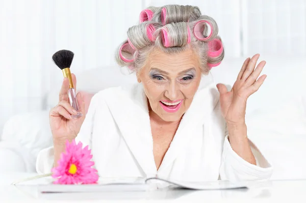 Старшая женщина в роликах для волос — стоковое фото