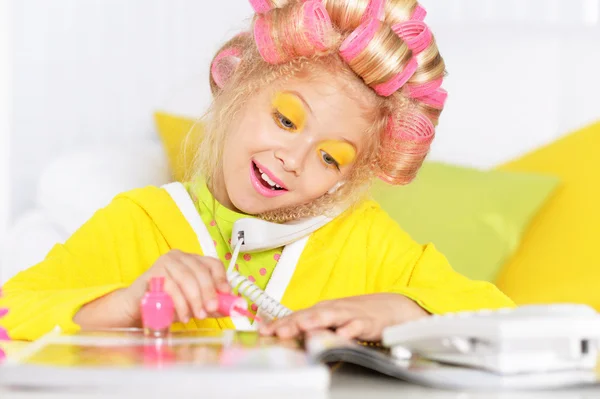 Liten flicka i papiljotter och telefon — Stockfoto