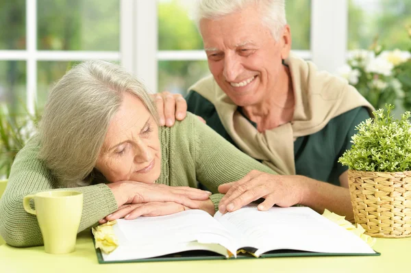 Pareja mayor con libro en casa — Foto de Stock