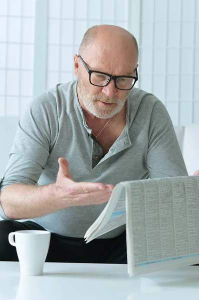 Portret van senior man met krant — Stockfoto