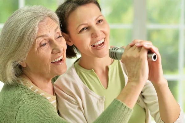 Mulher sênior com filha cantando no microfone — Fotografia de Stock