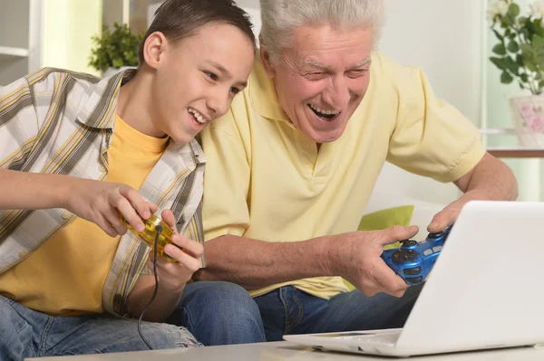 Menino e avô jogando jogo de computador — Fotografia de Stock