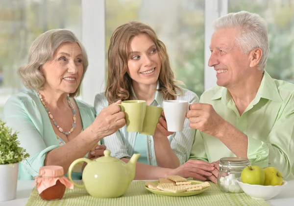 Fille avec parents aînés buvant du thé — Photo