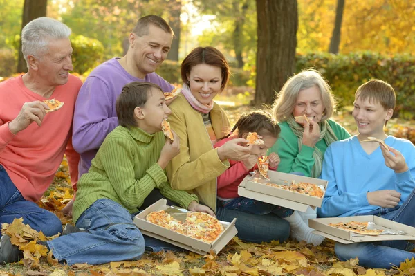 Familjen äta pizza i park — Stockfoto