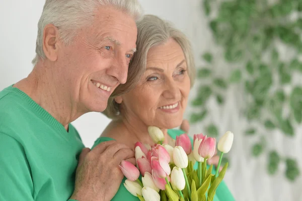 Senior man gives flowers to a woman — Stock Photo, Image