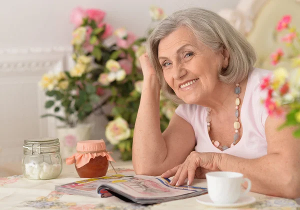Beautiful older woman reading magazine — Stock Photo, Image
