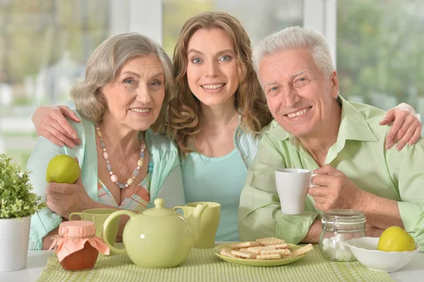 daughter with senior parents drinking tea