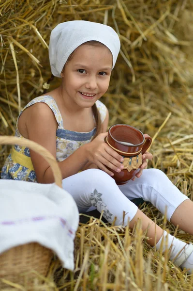 Kleines Mädchen mit Milch im Feld — Stockfoto