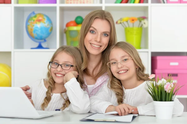 Mãe ajudando suas filhas com lição de casa — Fotografia de Stock