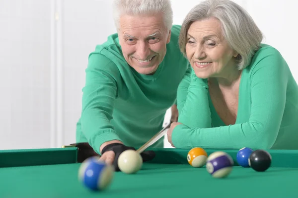 Old couple playing billiard — Stock Photo, Image