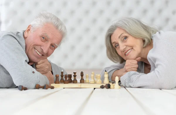 Lyckliga äldre paret spelar schack — Stockfoto