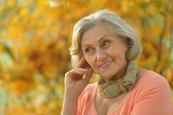 Oudere vrouw in herfstpark — Stockfoto