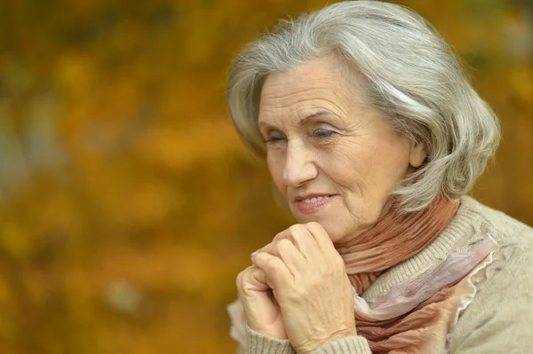 Старшая женщина в осеннем парке — стоковое фото