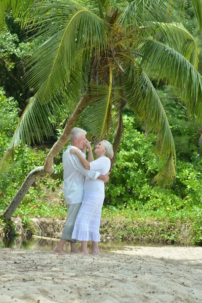 Bejaarde echtpaar rusten op tropisch strand — Stockfoto