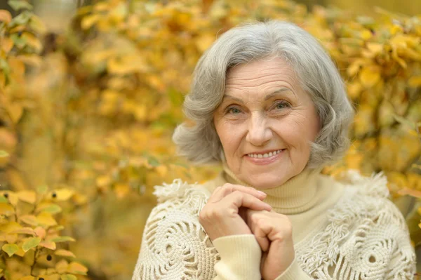 Donna anziana nel parco di autunno — Foto Stock