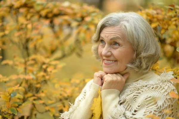 Donna anziana nel parco di autunno — Foto Stock