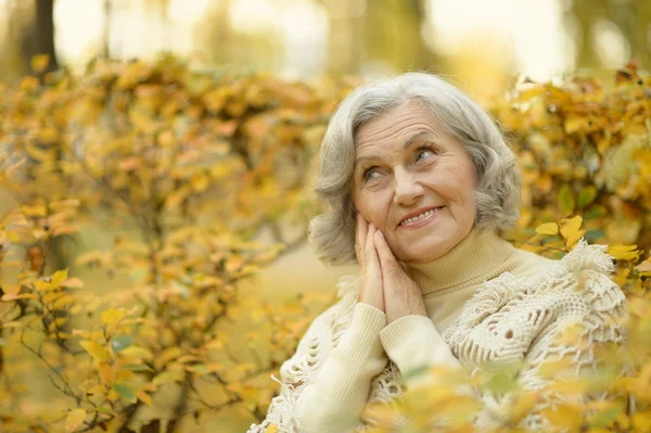 Oudere vrouw in herfstpark — Stockfoto