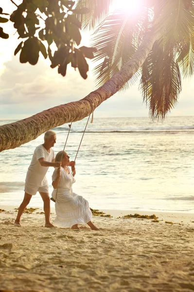 Bejaarde echtpaar rusten op tropisch strand — Stockfoto