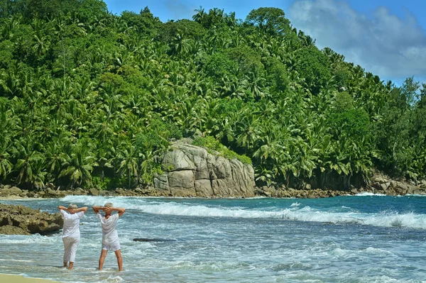 Pareja de ancianos descansar en la playa tropical — Foto de Stock