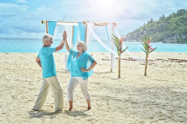 Casal de idosos descansam na praia tropical — Fotografia de Stock