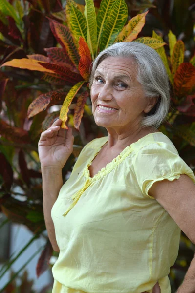 Oudere vrouw in tropische tuin — Stockfoto