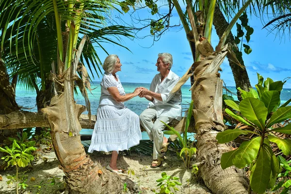 Ηλικιωμένο ζευγάρι αναπαυθούν σε τροπική παραλία — Φωτογραφία Αρχείου