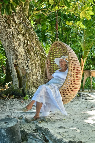 Kvinna sitter på en gunga vid stranden — Stockfoto