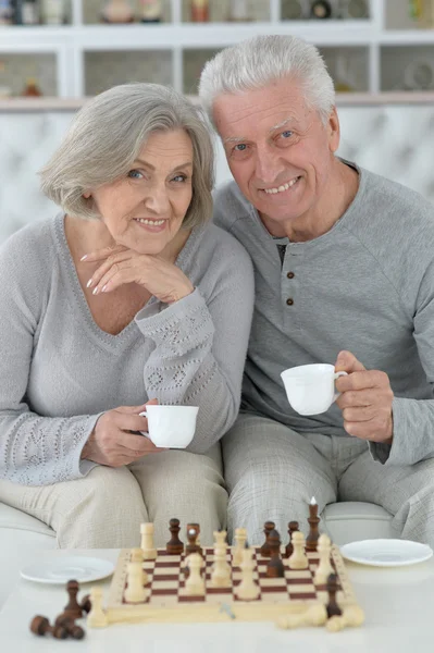 Счастливая старшая пара играет в шахматы — стоковое фото