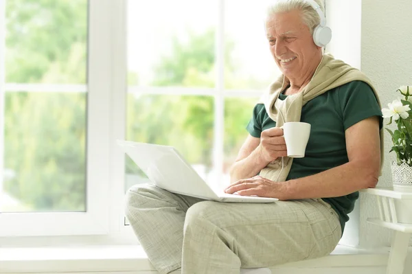 Homme âgé avec ordinateur portable à la maison — Photo