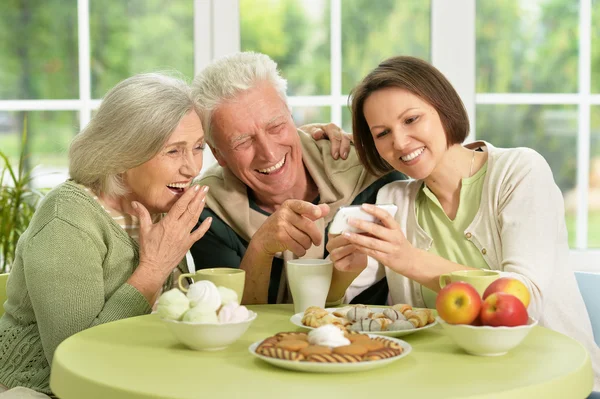 Daughter with senior parents drinking tea — Stock Photo, Image