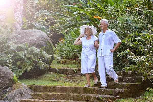 Bejaarde echtpaar in tropische tuin — Stockfoto