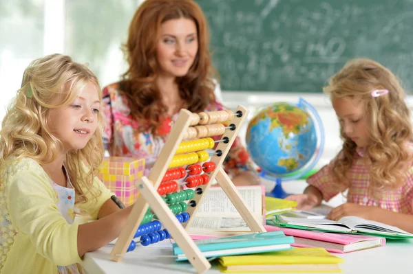 Professor com duas meninas na lição — Fotografia de Stock