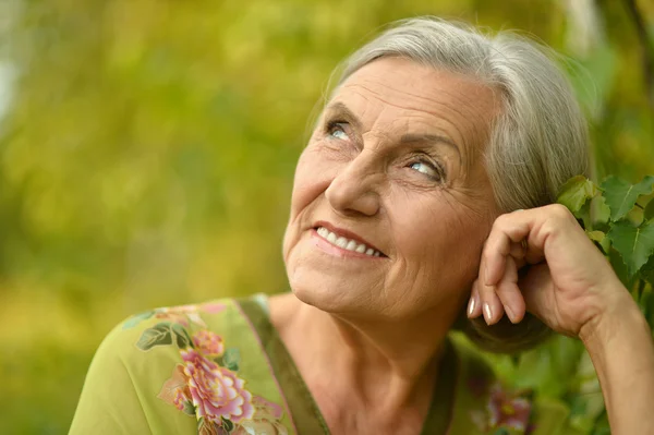 Senior woman in green park — Stock Photo, Image