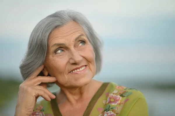 Donna anziana vicino al lago — Foto Stock