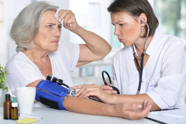 Lekarz mierzy ciśnienie jej starszy pacjent — Zdjęcie stockowe