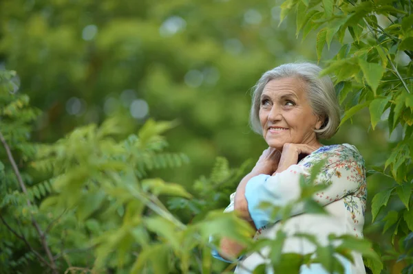 Старша жінка в зеленому парку — стокове фото