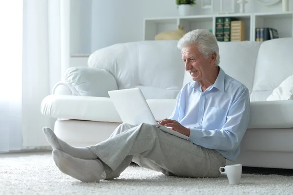 Senior homme à la maison avec ordinateur portable — Photo