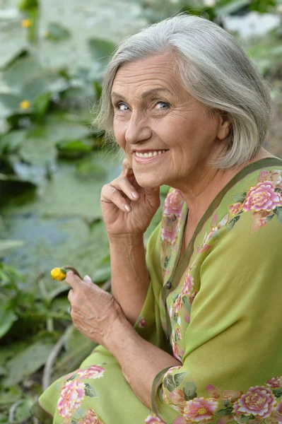 Elderly woman near lake — Stock Photo, Image